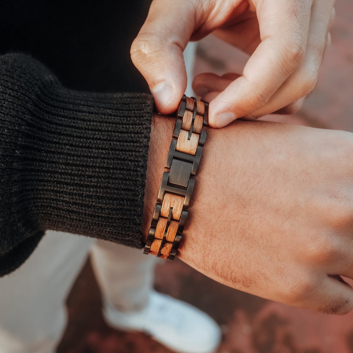 "Kanon", a stylish bracelet featuring oak and gray elements worn on wrist.