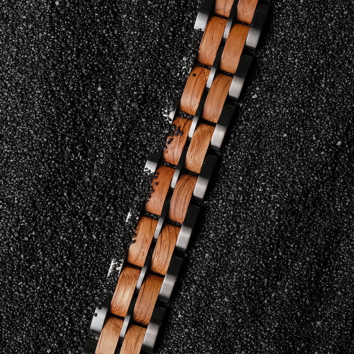 "Kanon", a stylish watch strap, features an oak and gray design set against a textured dark background.