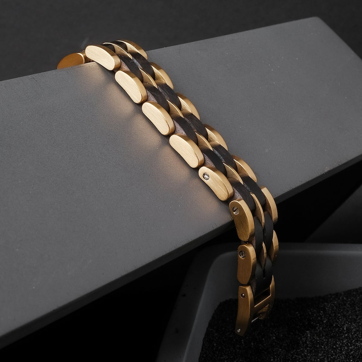 "Kanon", a stylish bracelet featuring black maple and gold elements on a modern, angular surface.