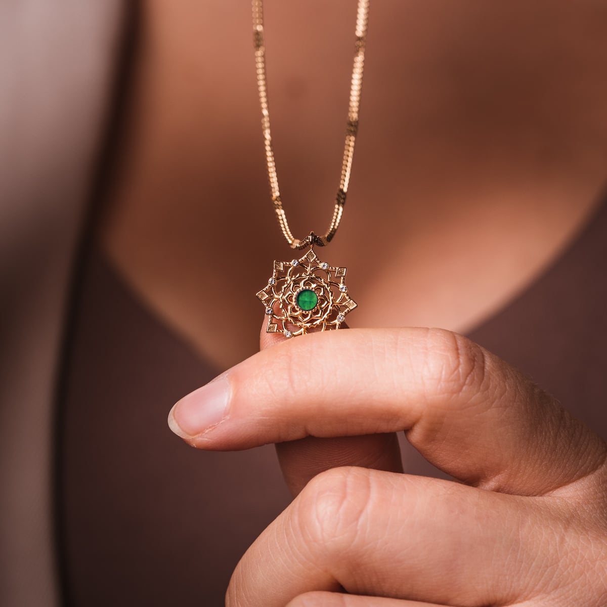 "Aphonia Necklace" necklace with green marble and gold accents, featuring intricate design.