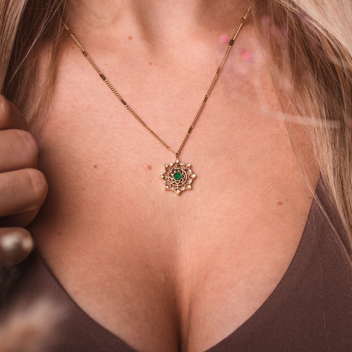 "Aphonia Necklace", a necklace featuring green marble and gold with an intricate, elegant design.