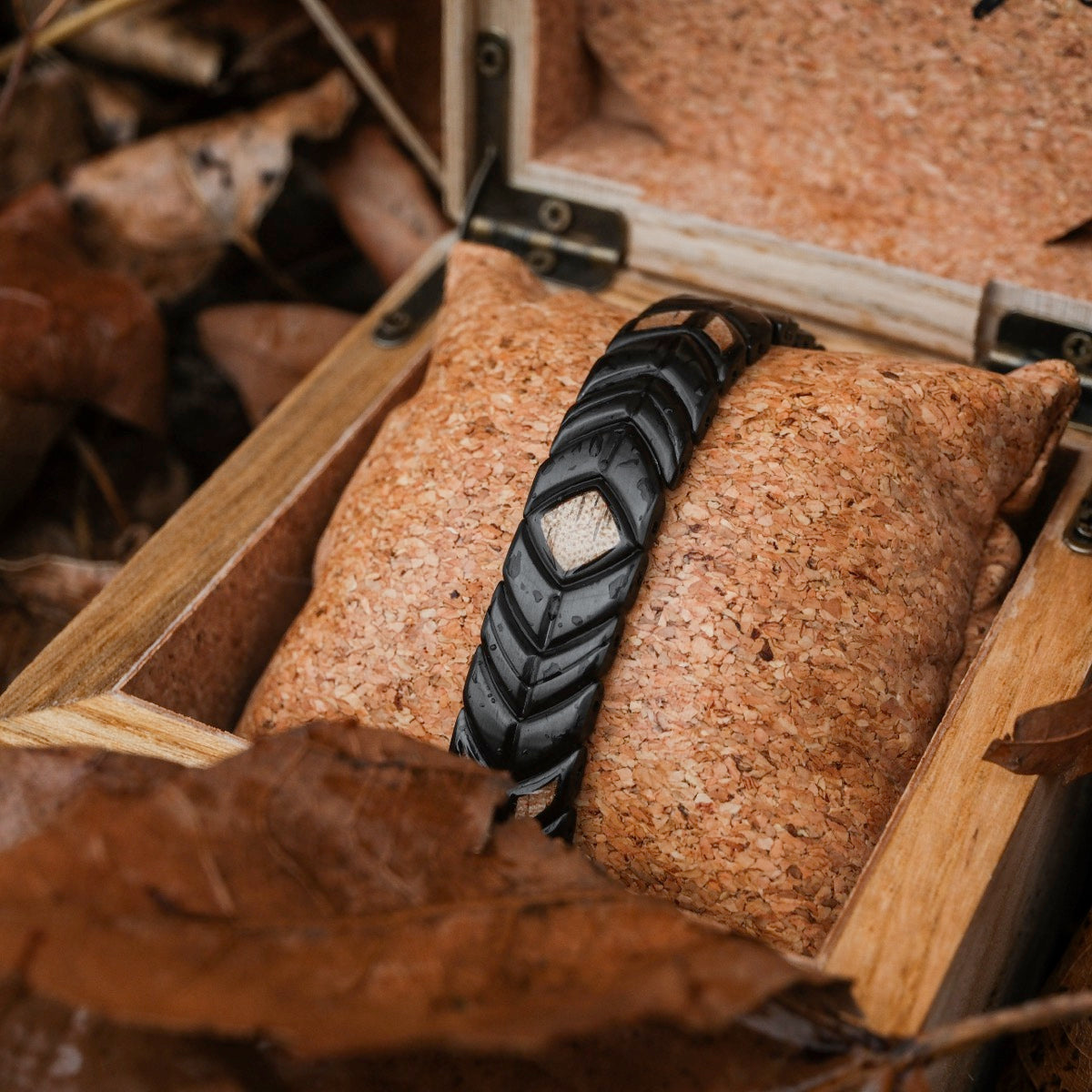 "Prelude" bracelet, crafted from koa wood and black material, showcased in a rustic setting.