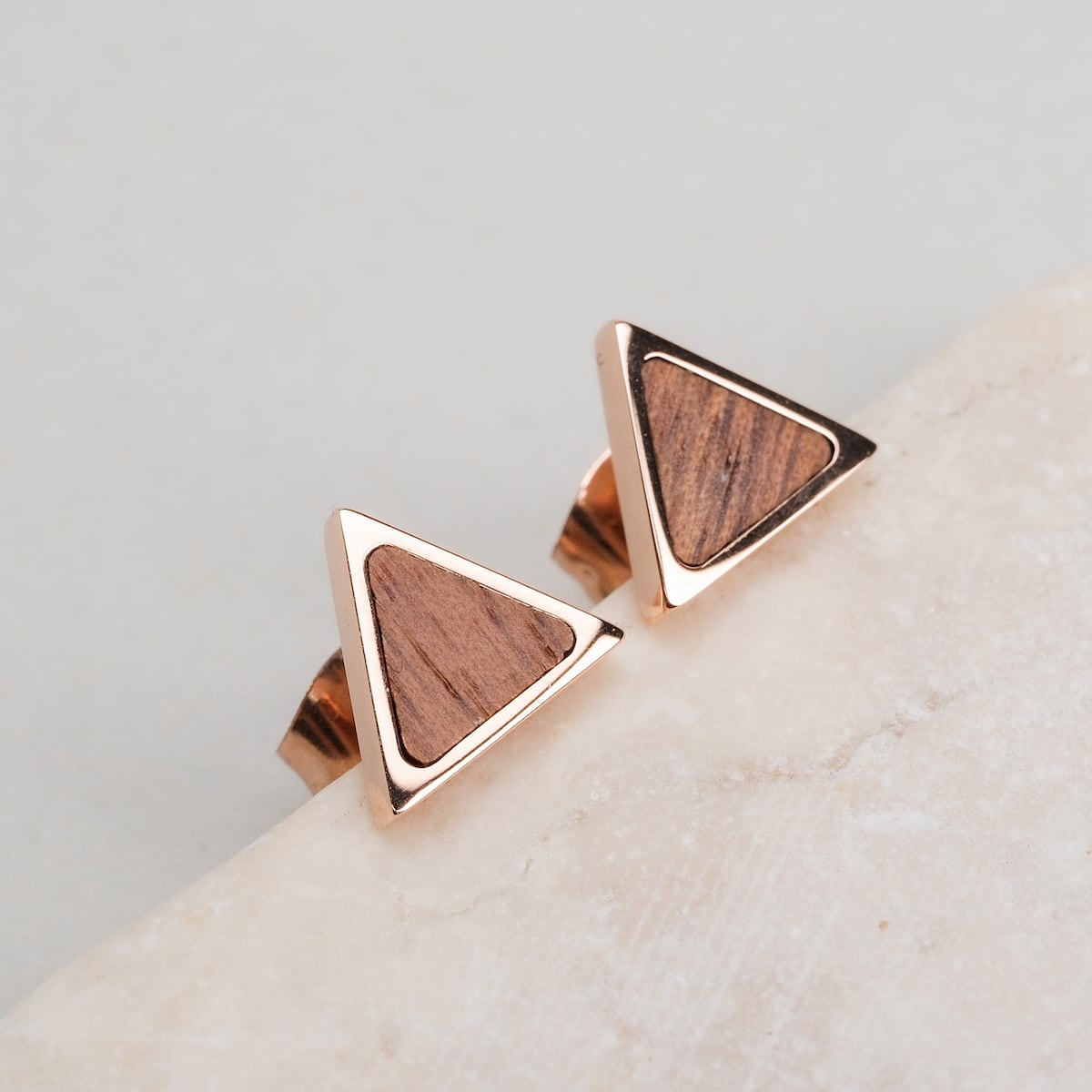 "Scale Earrings": Walnut and rose gold earrings with a sleek triangular design.
