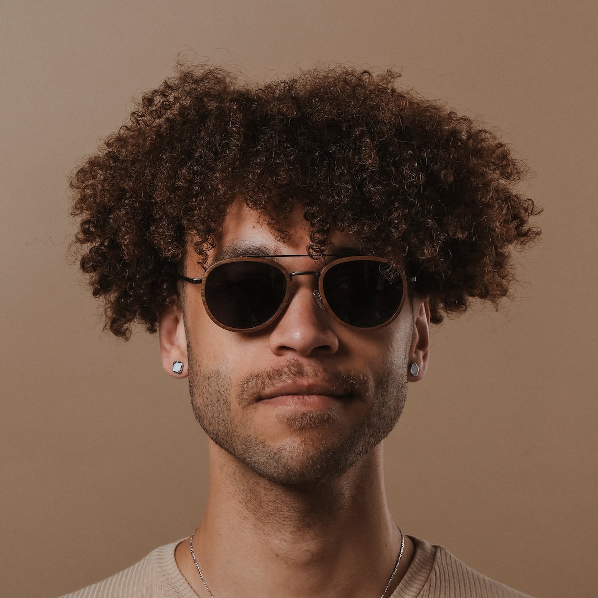 "The Risky" sunglasses in Walnut/Dark Gray, featuring a round frame and modern style.