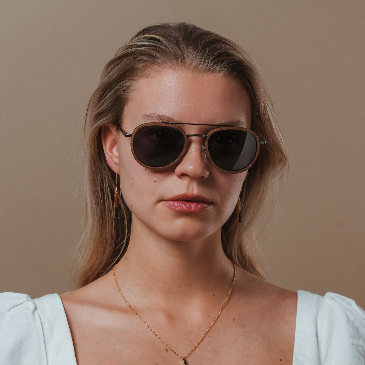 "The Risky" sunglasses, featuring a sleek walnut and dark gray style.