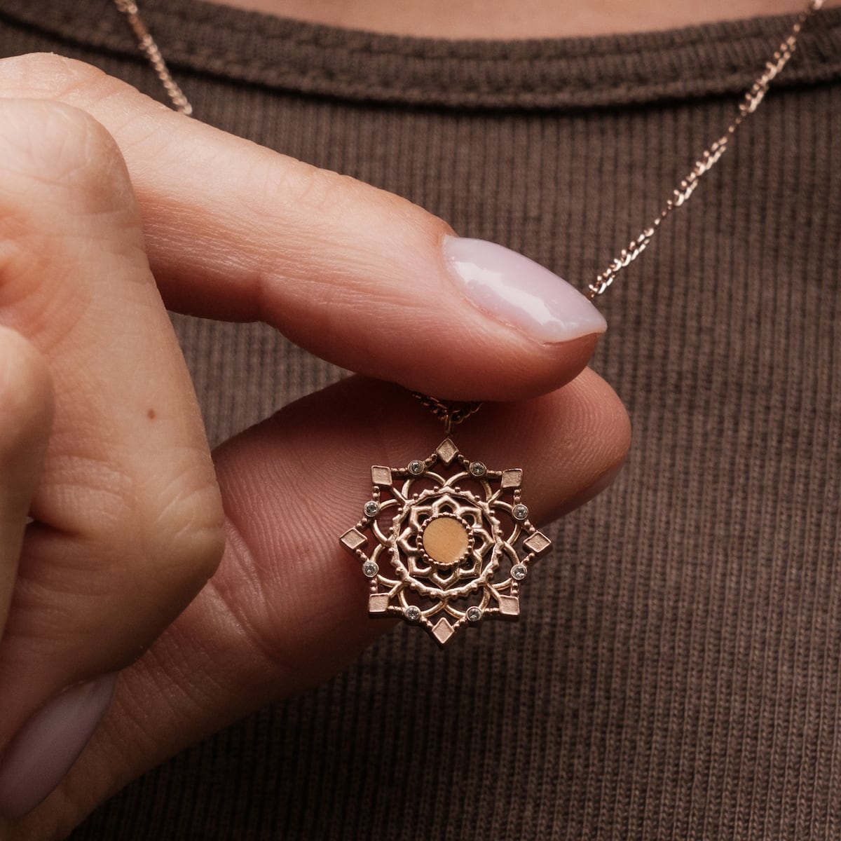 "Aphonia Necklace" necklace in olive and rose gold with intricate mandala design.