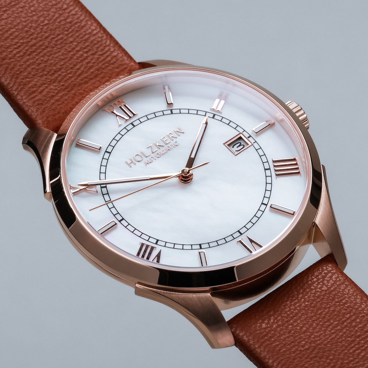 "Milestones", an elegant wristwatch featuring a nacre dial and brown leather strap.