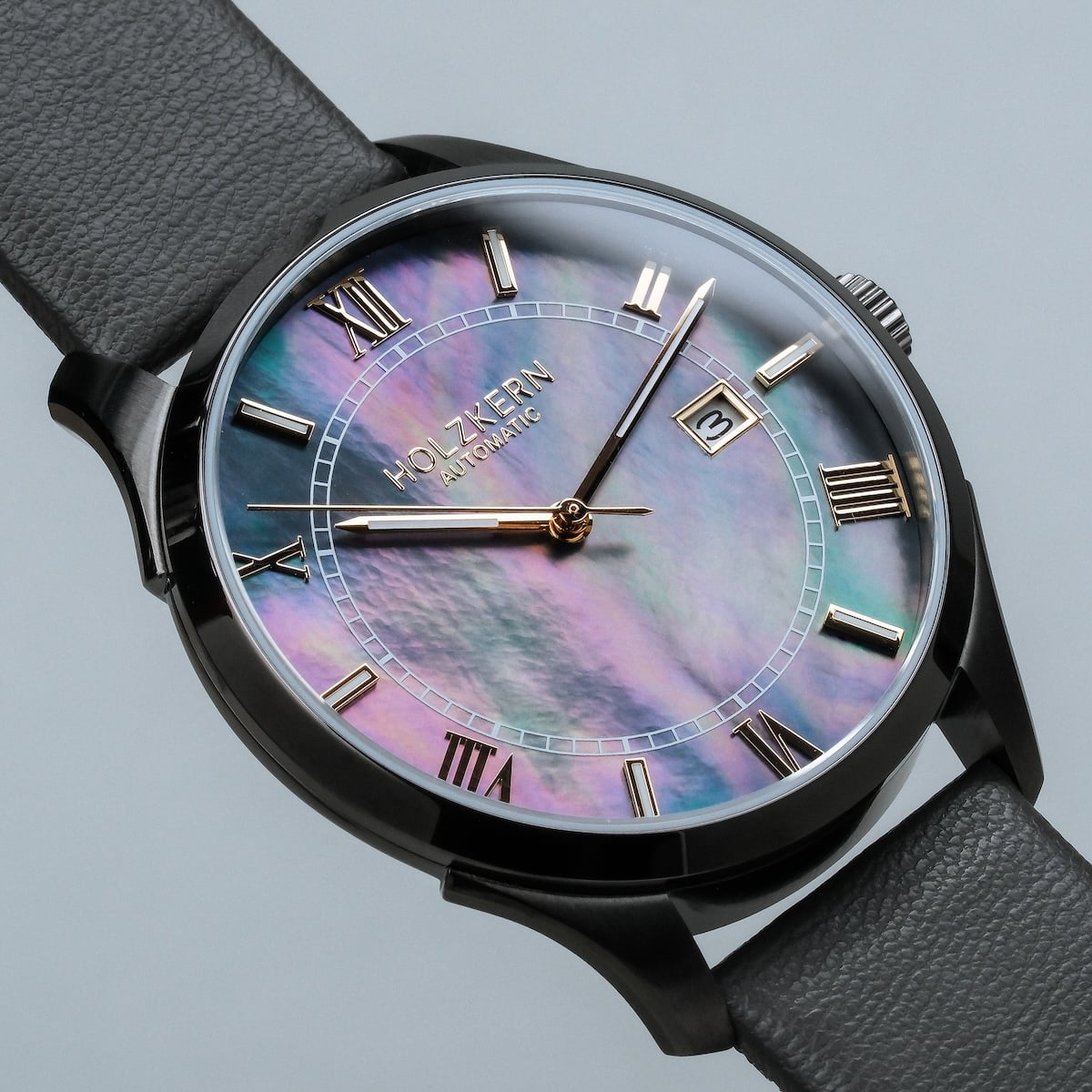 "Milestones" watch with a nacre face and dark gray band, featuring a sleek and elegant design.