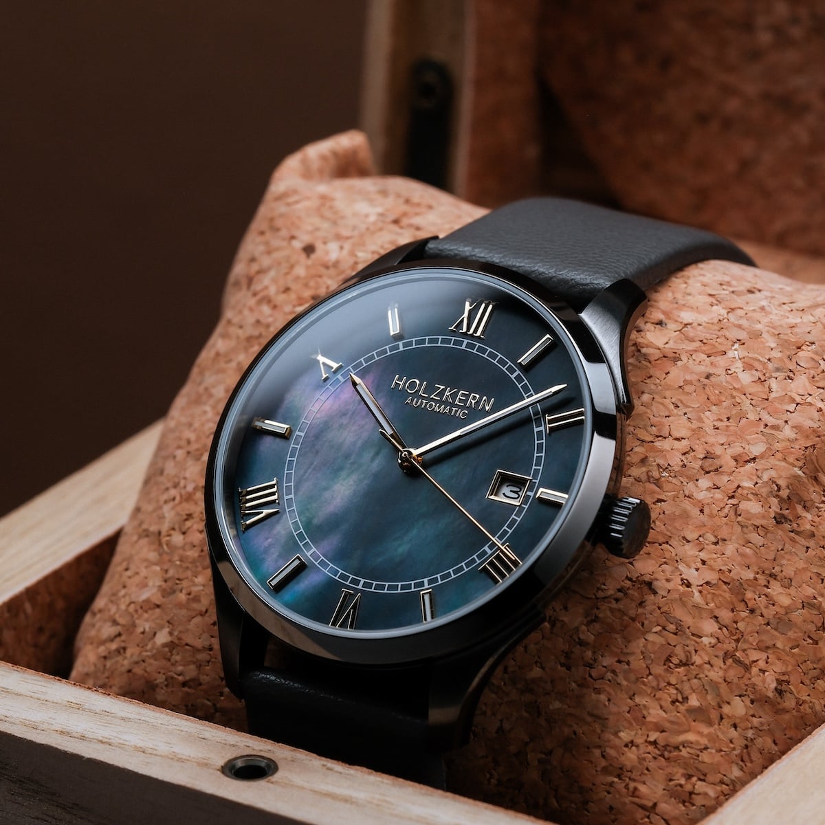 "Milestones" watch featuring a nacre face and dark gray strap, offering a sophisticated and elegant design.