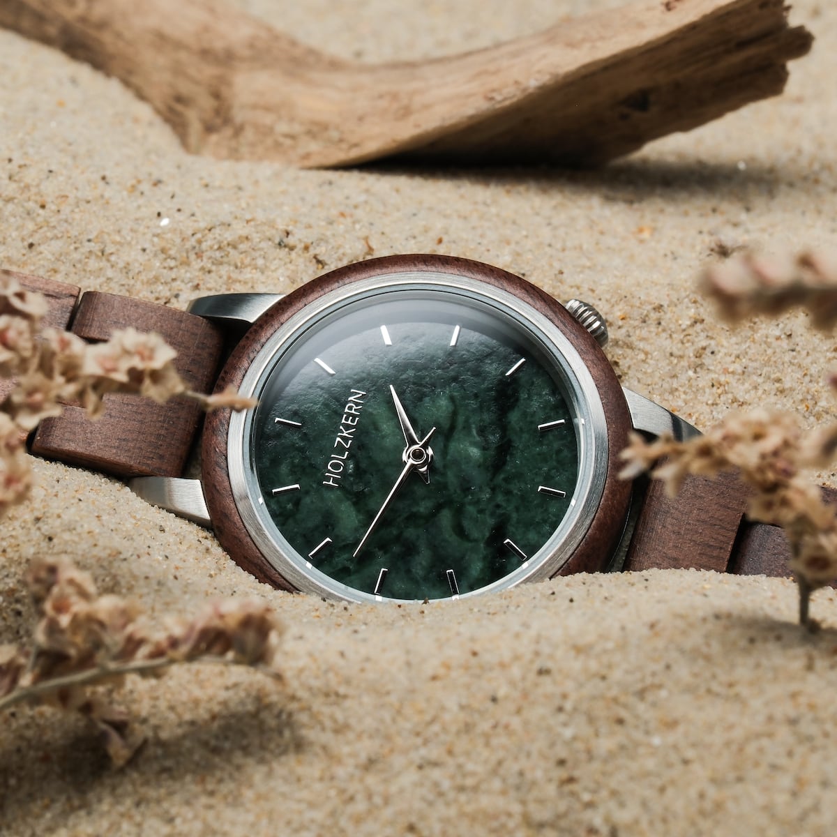 "Anakena" watch featuring a walnut and marble design nestled in sand, with a blend of natural elegance and rugged style.
