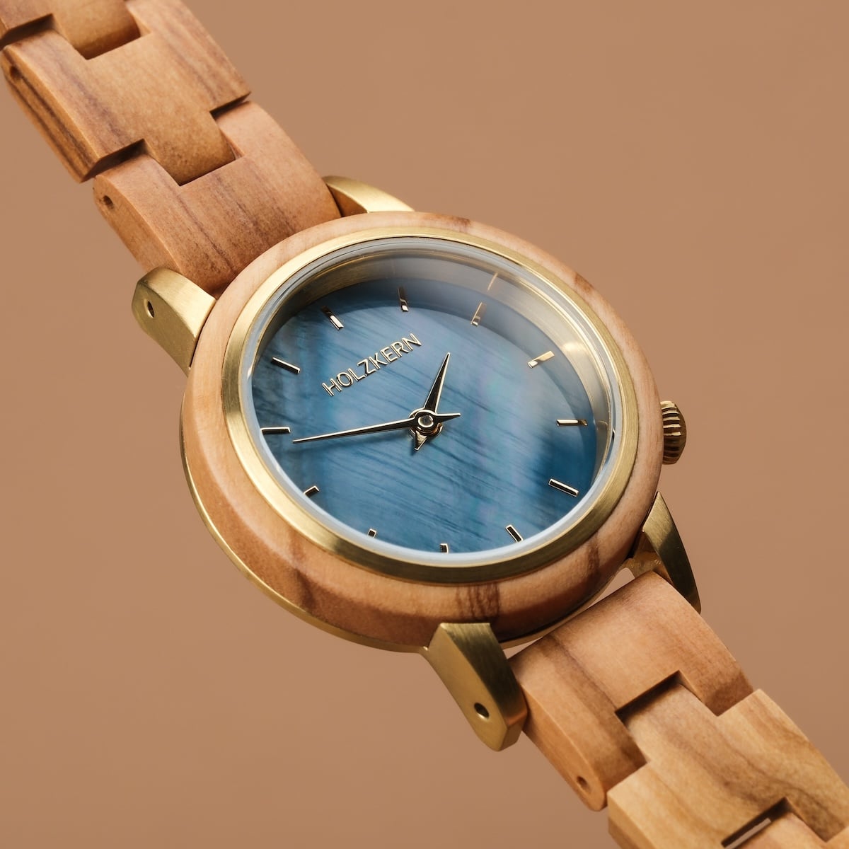 "Antrim" watch with an olive band and nacre face, featuring a natural, elegant design.