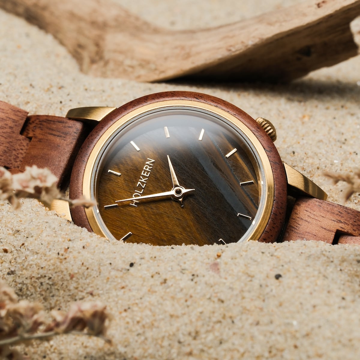 "Costa del Sol" watch featuring a Koa wood band and Tiger's Eye dial, styled naturally on sand.