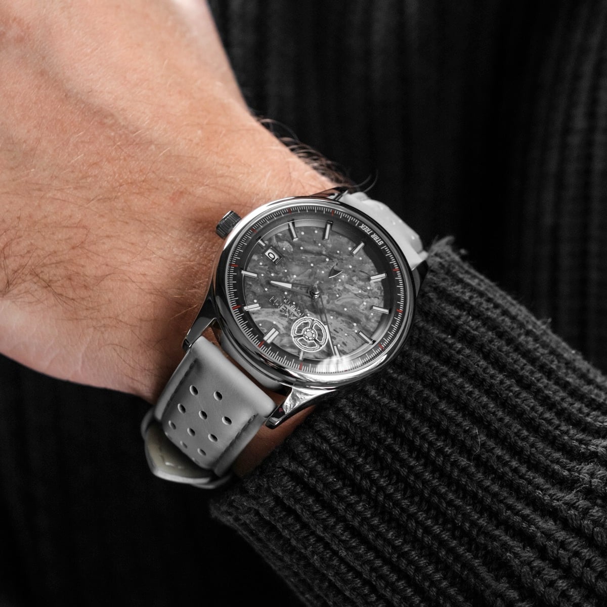 "DS9", a stylish wristwatch featuring a marble and light gray design, on a person's wrist.