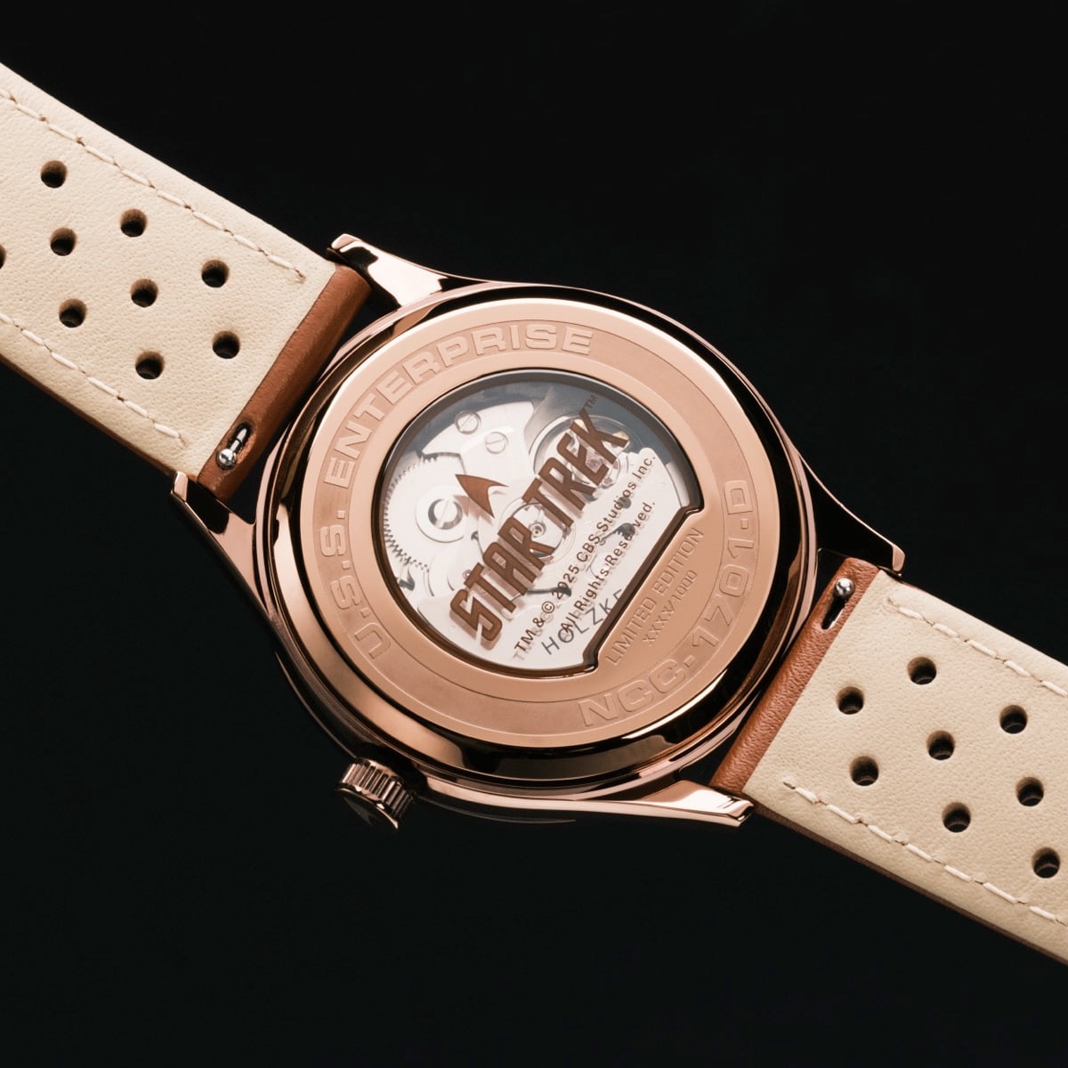 "NCC-1701-D", stylish wristwatch featuring rose gold finish and cream leather strap.