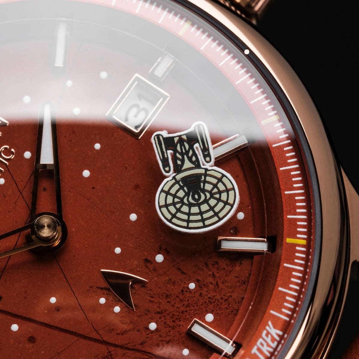 "NCC-1701-D", a watch with a red and copper design, featuring space-themed elements and a sleek appearance.