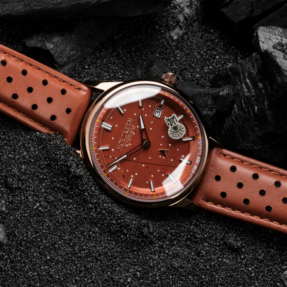 "NCC-1701-D" watch features a jasper-red dial with elegant detailing and a perforated leather strap.