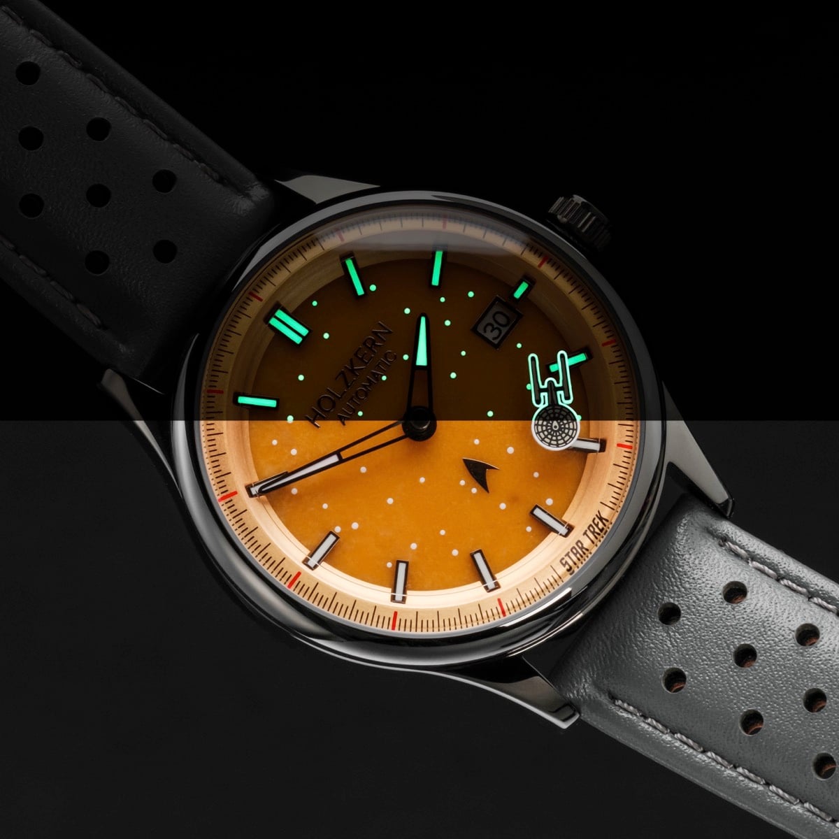"NCC-1701", wristwatch with a vibrant orange dial and jade accents, featuring a sleek dark gray strap.