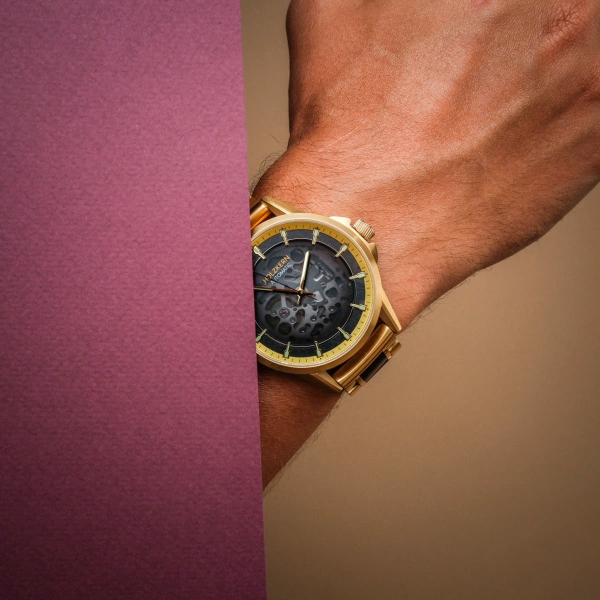 "Flowfinder", a gold and maple watch, elegantly styled with a textured black face and gold accents.
