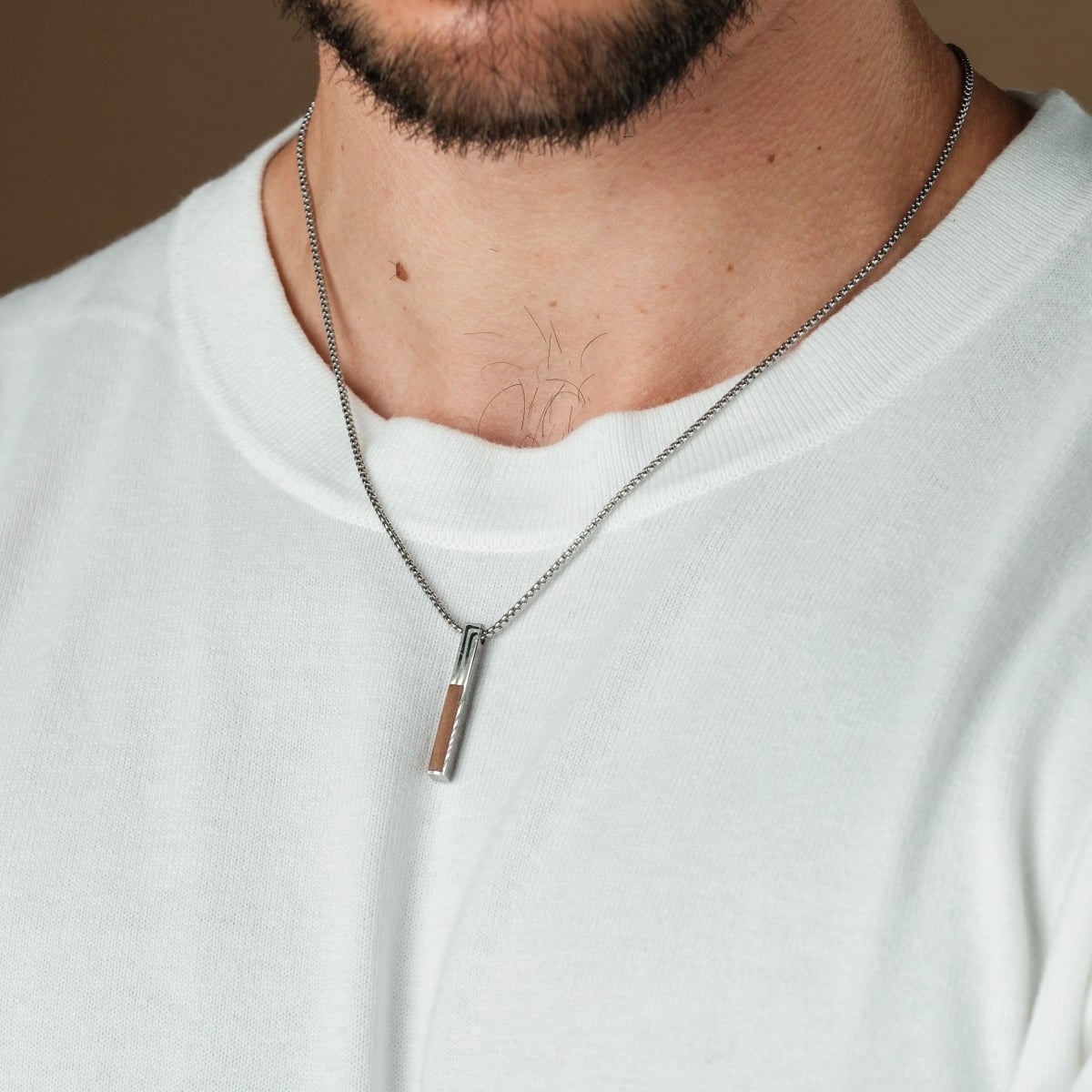 "Campania Necklace", a stylish necklace featuring walnut and Damascus materials, elegantly worn with a casual outfit.