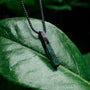 "Campania Necklace" necklace featuring green marble and Damascus, exuding a sophisticated, natural elegance on a lush leaf backdrop.