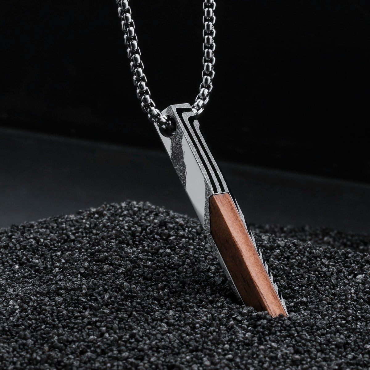 "Campania Necklace" necklace featuring a sleek walnut and Damascus steel design on a textured dark background.