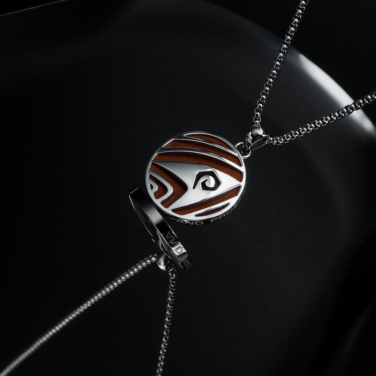 "Operations Necklace" features a round pendant design with jasper and silver accents on a sleek chain.