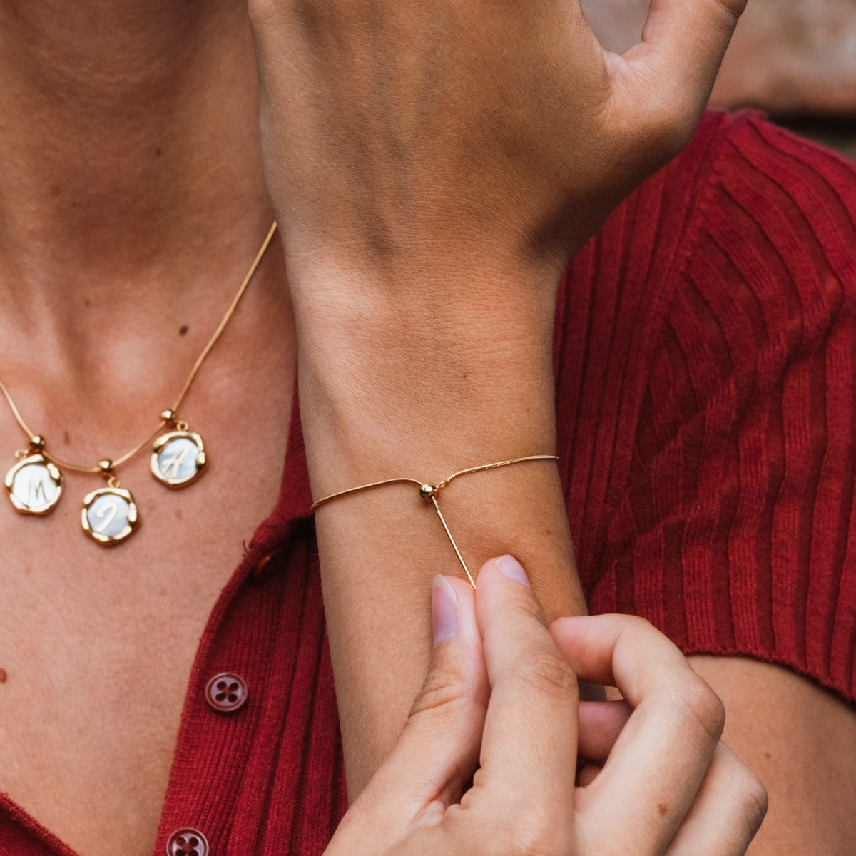 "Charms Necklace", a gold necklace featuring charm pendants with a delicate and elegant design.