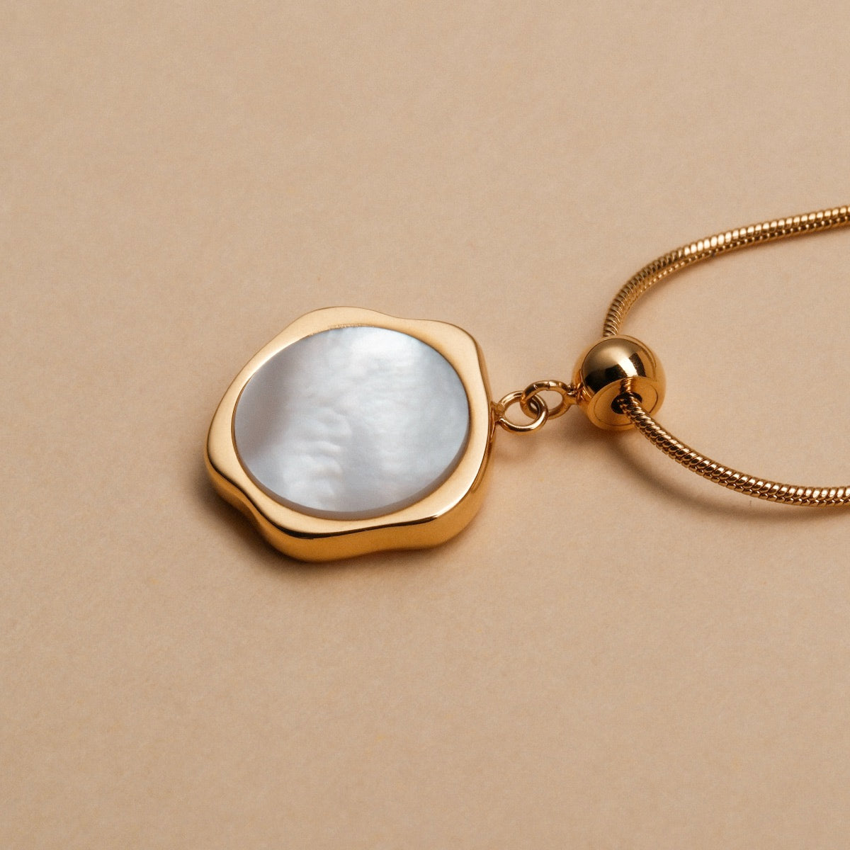 "Charms Bracelet", gold charms bracelet featuring a modern, elegant style with a pearl-like pendant.