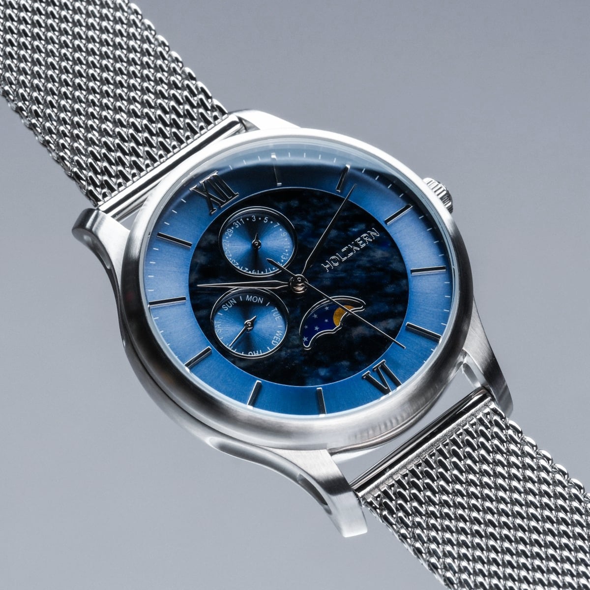 "Moonrise", marble and silver watch with a blue dial and mesh strap, showcasing a sophisticated design.