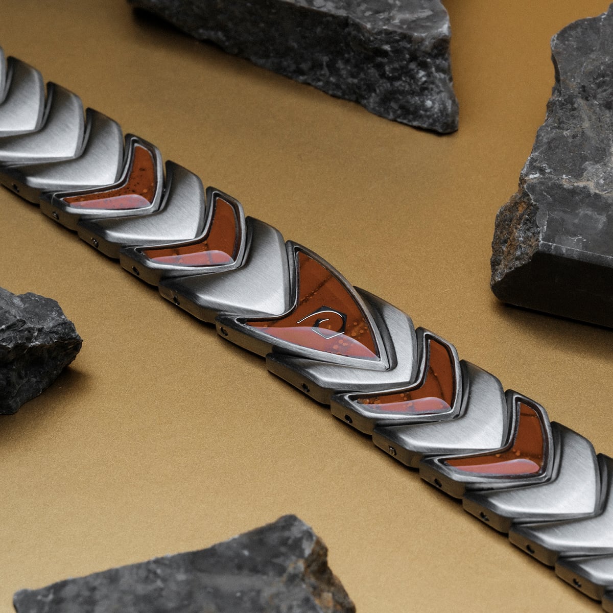 "Operations" bracelet with a sleek geometric design in metallic tones, featuring warm jasper and silver accents.