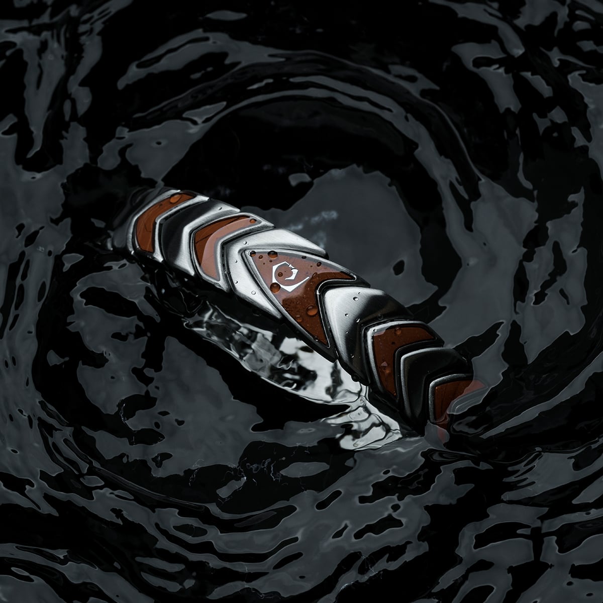 "Operations", bracelet with a sleek jasper and silver chevron design, set in dark water.