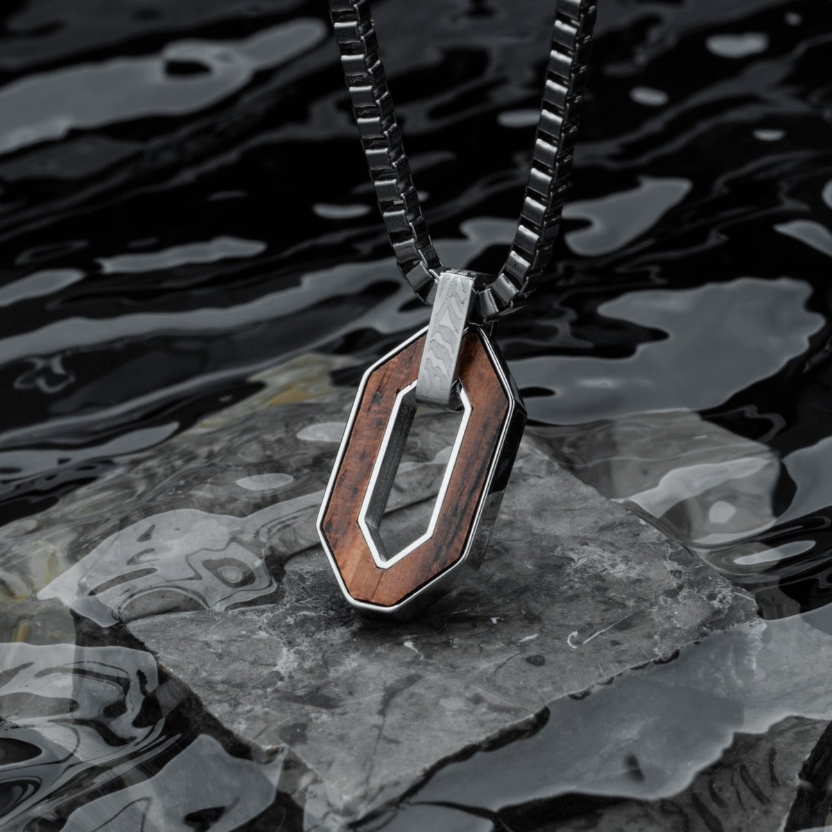 "Interplay Necklace", a stylish necklace featuring a walnut and Damascus steel design with a modern geometric style.