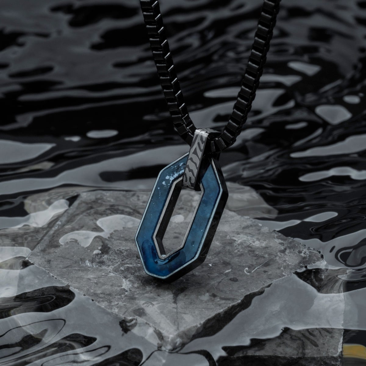 "Interplay Necklace" necklace, featuring a bold sodalite stone and Damascus steel design, styled with a luxurious, modern look.
