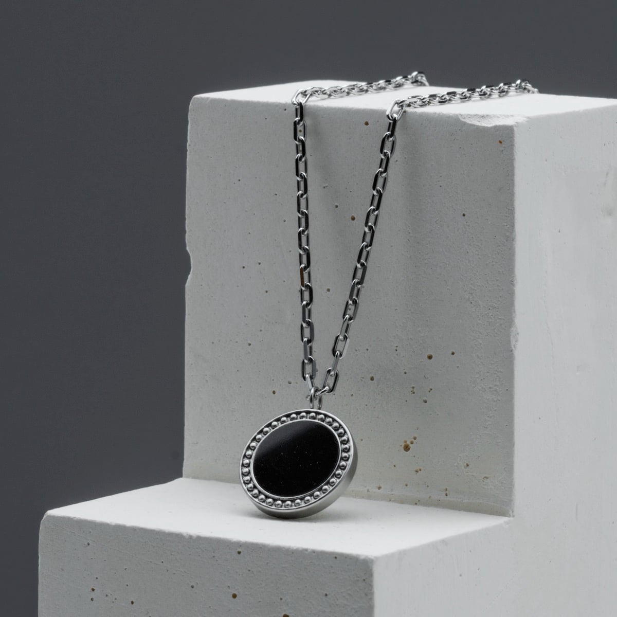 "Interplay Necklace" necklace featuring black marble and silver with an elegant, modern design.
