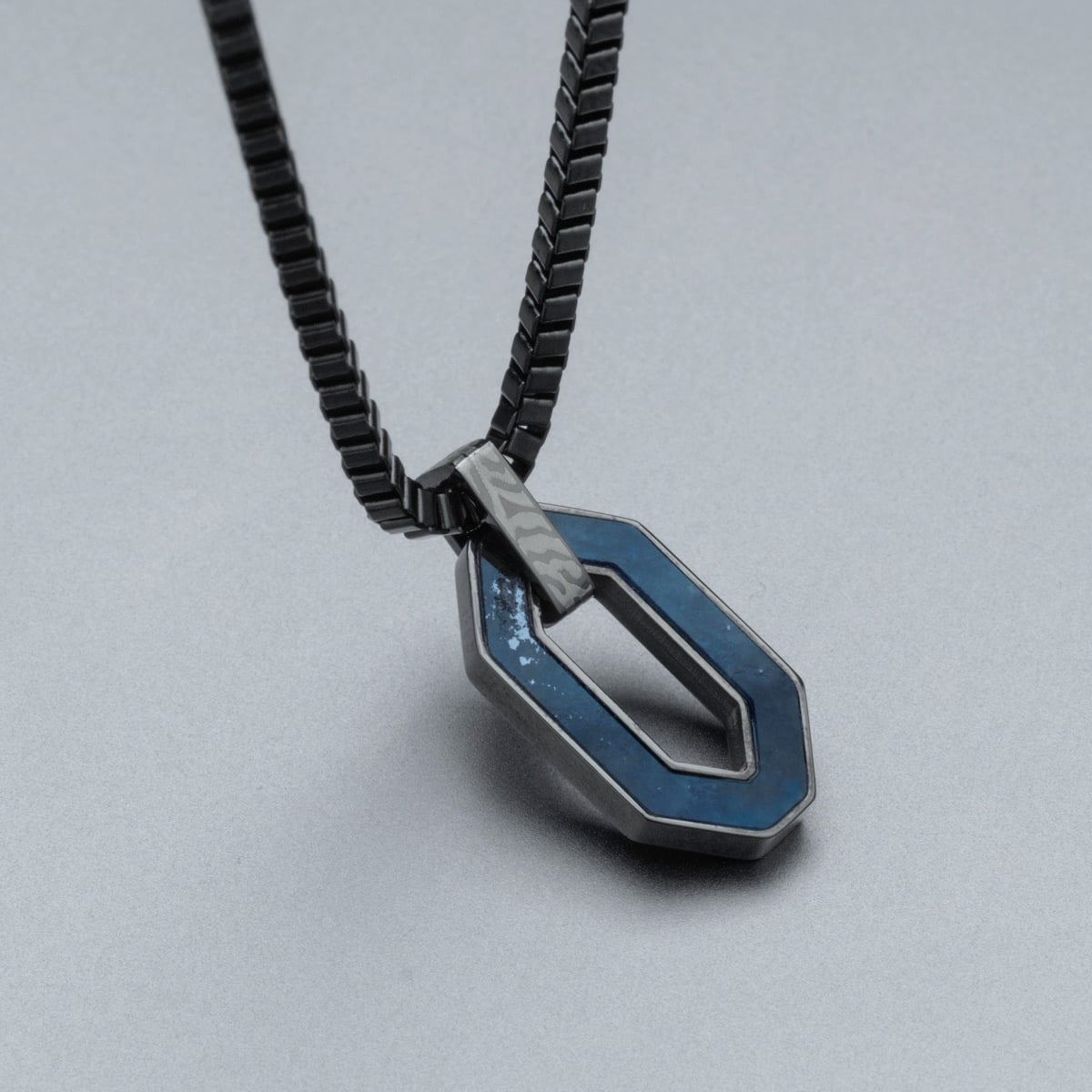 "Interplay Necklace": a modern necklace featuring sodalite and Damascus elements.