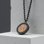 "Interplay Necklace", a stylish necklace featuring a Koa wood centerpiece and gray accents.