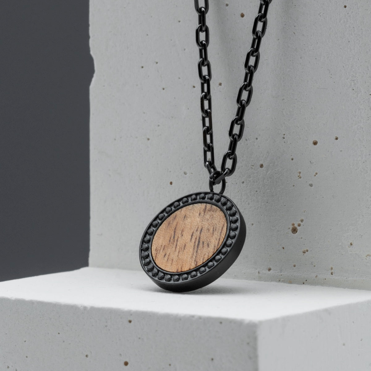 "Interplay Necklace", a stylish necklace featuring a Koa wood centerpiece and gray accents.