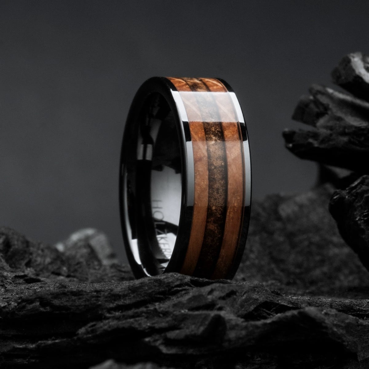 "Sumo Ring": stylish ring featuring whiskey wood and ceramic, set against a dark, textured backdrop.