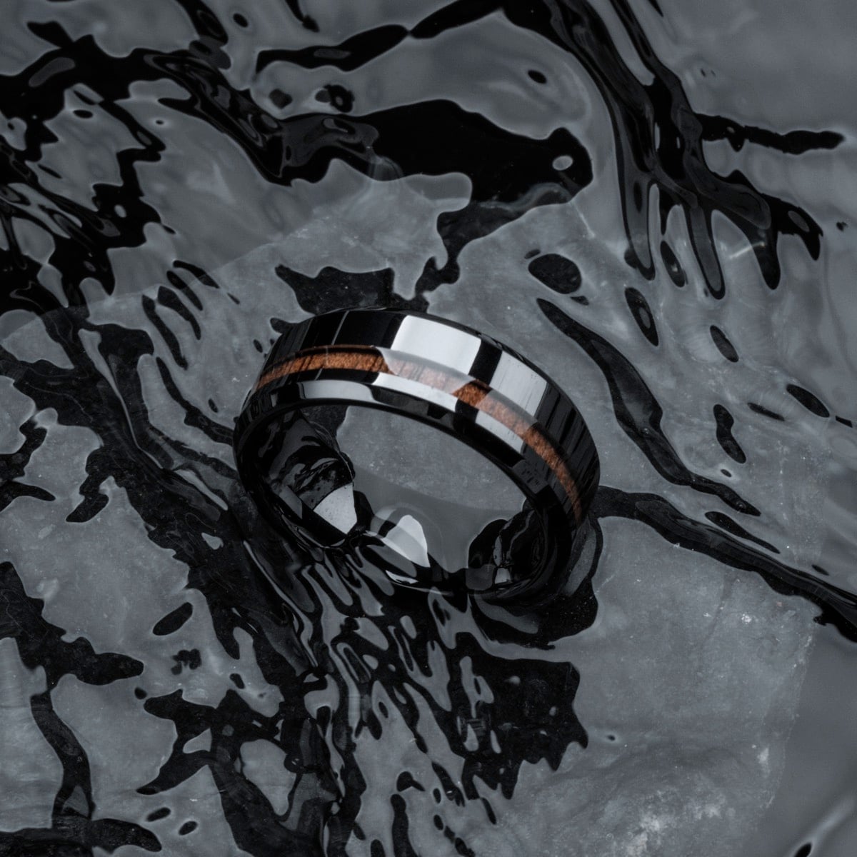 "Sumo Ring", a sleek ring featuring a modern blend of walnut and ceramic, with a polished finish.