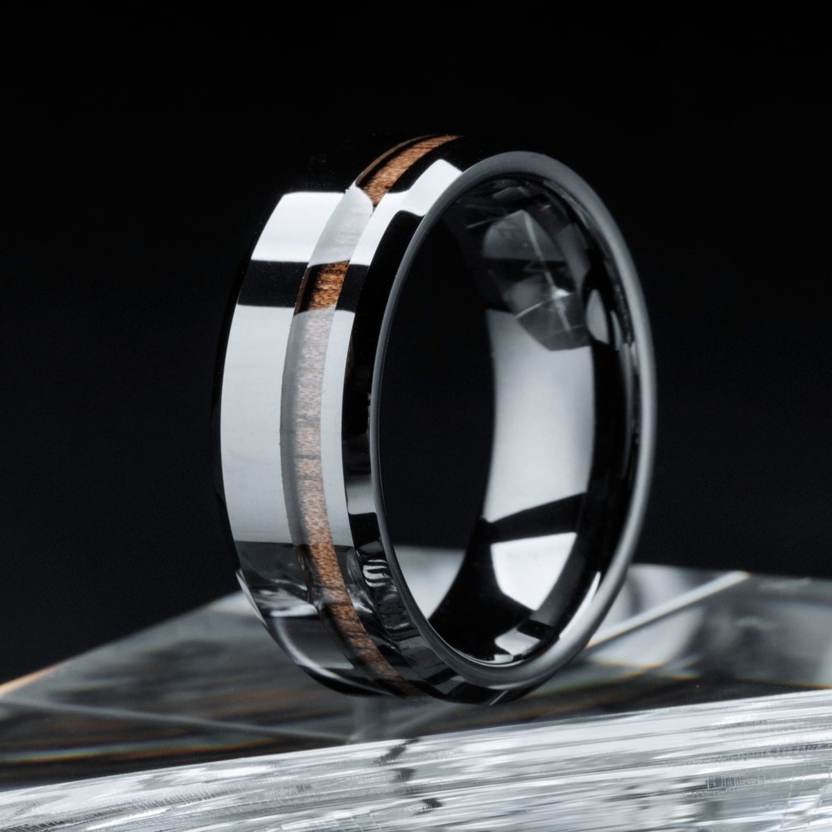 "Sumo Ring", a sleek ring featuring walnut and ceramic materials, with a modern, polished design.
