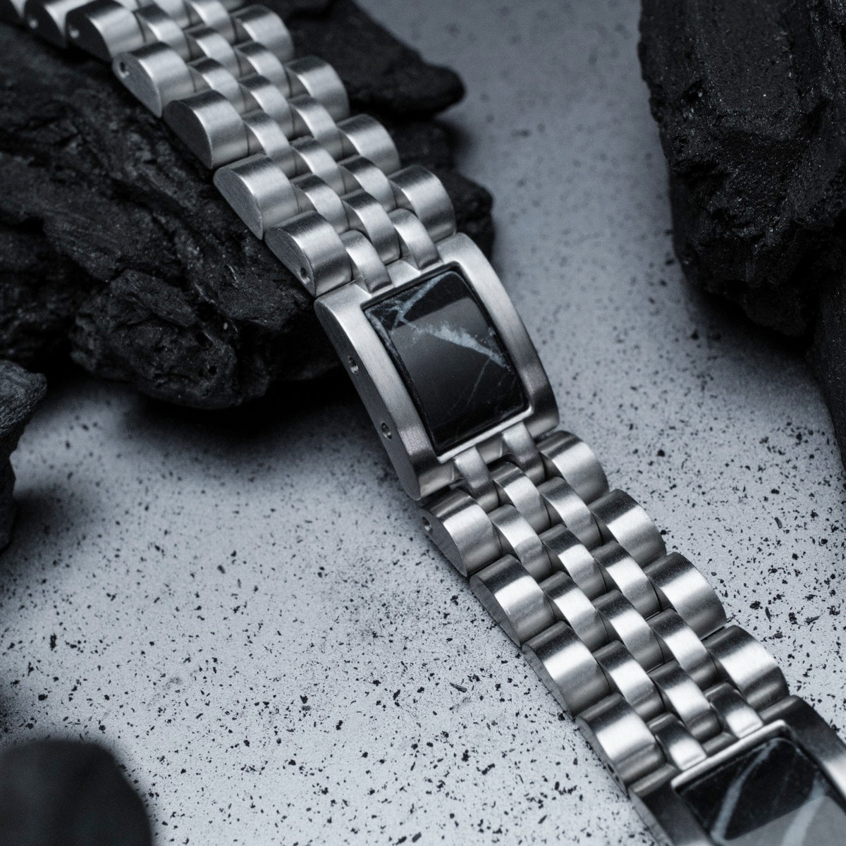 "Pentachord" wristband, featuring a sleek black marble and silver design.