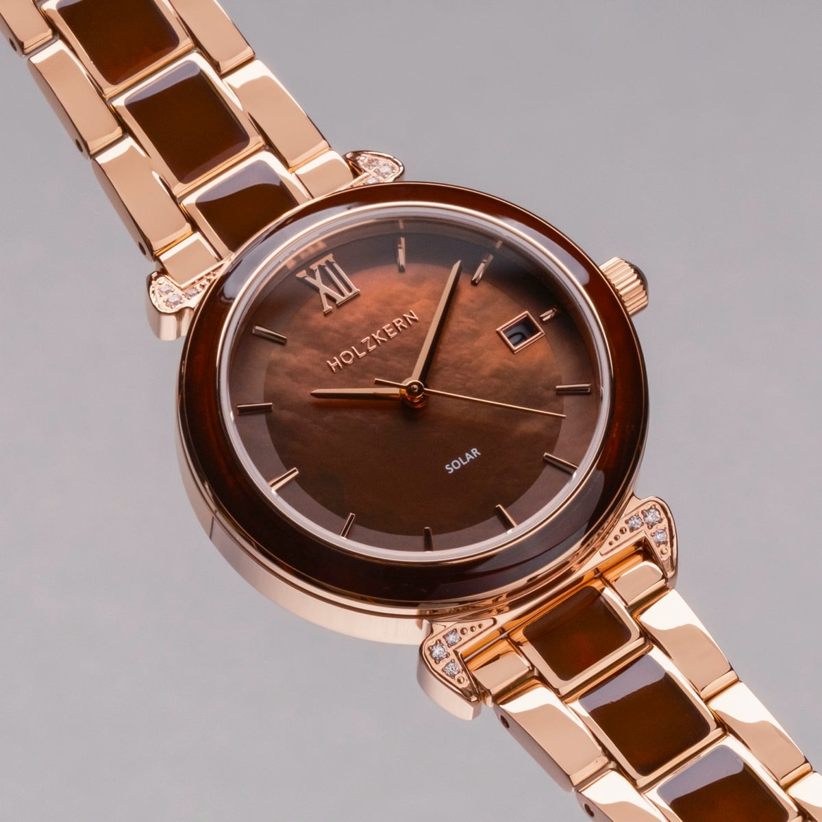 "Sunglister", a stylish watch featuring a brown mother-of-pearl dial and rose gold accents.