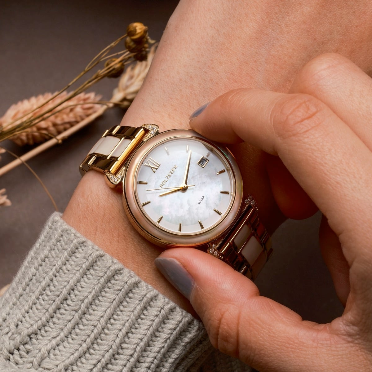 "Sunglister" watch featuring a mother-of-pearl face and elegant gold accents on the band.