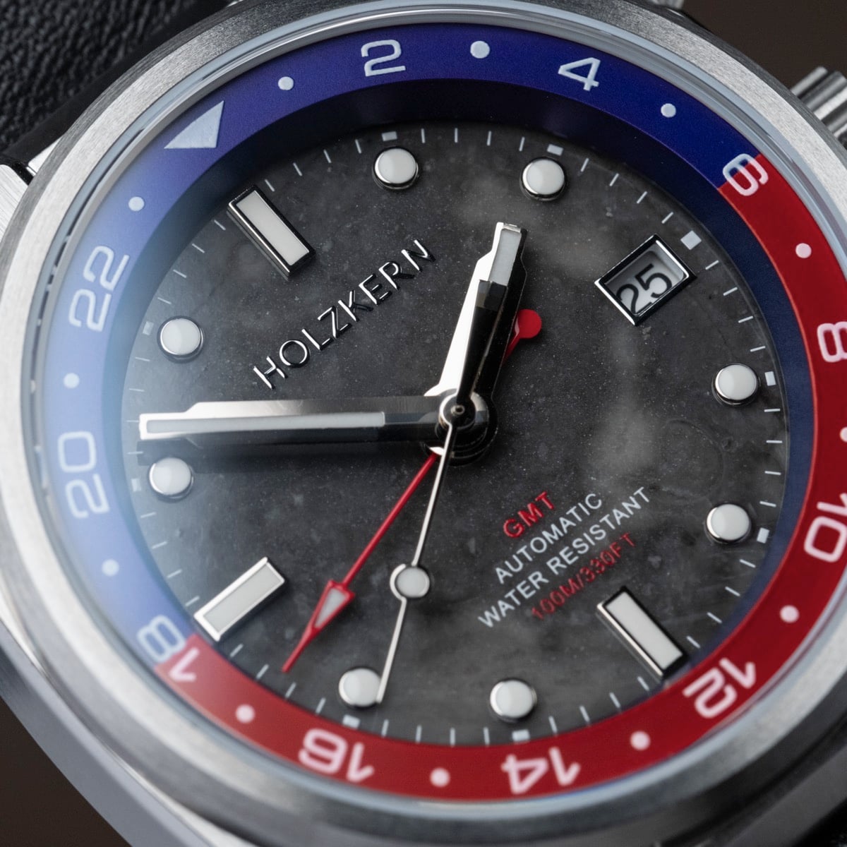 "GMT Cloudhopper", GMT watch with marble black face, automatic movement, and a sleek red and blue bezel design.