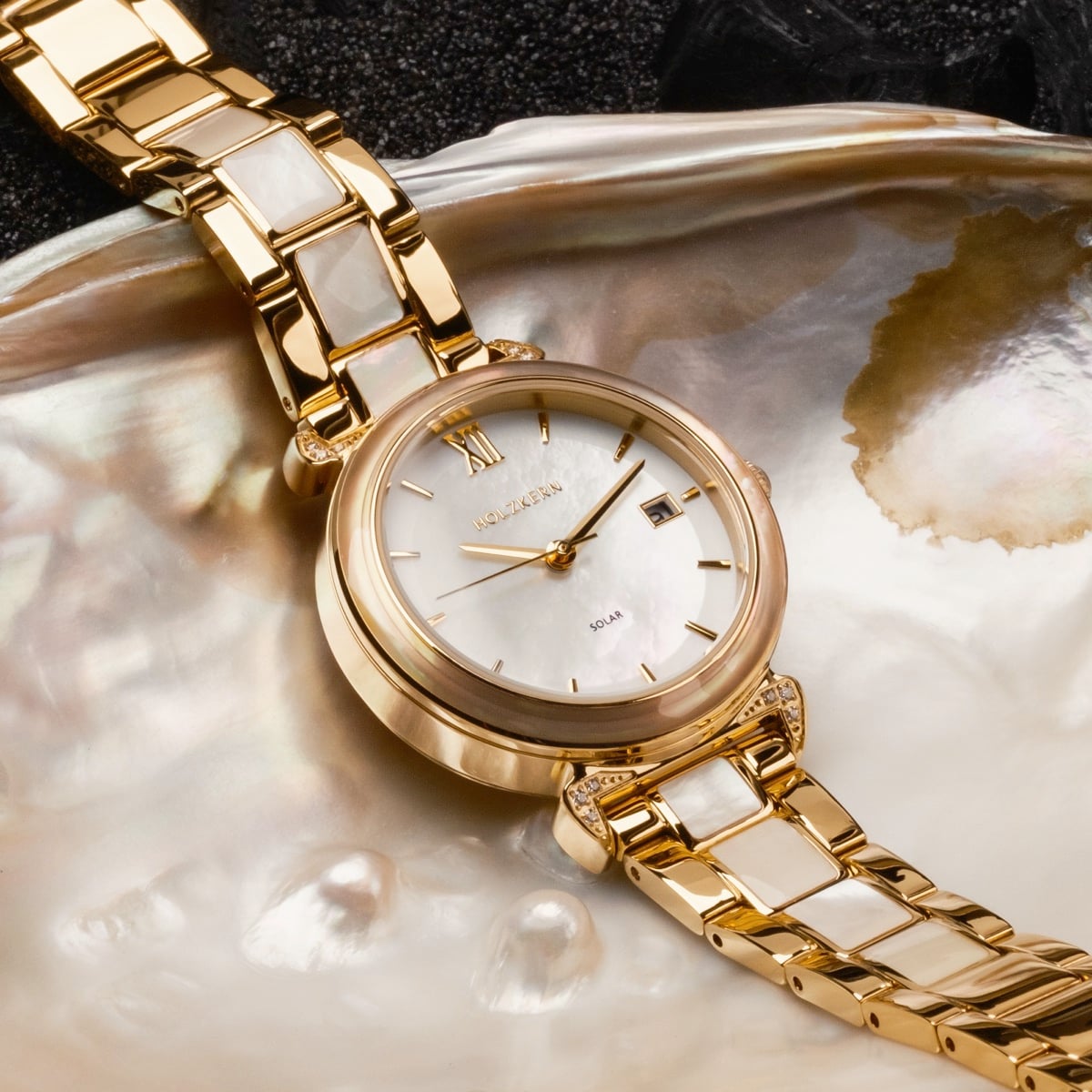 "Sunglister", a luxurious watch with a white mother-of-pearl face and gold accents.