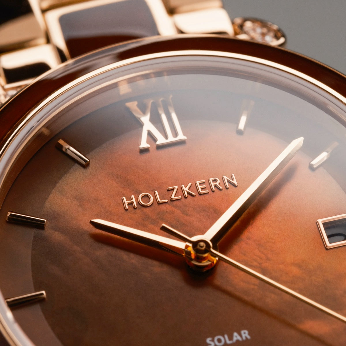 "Sunglister" watch with brown mother-of-pearl dial and rose gold accents, featuring elegant Roman numerals.