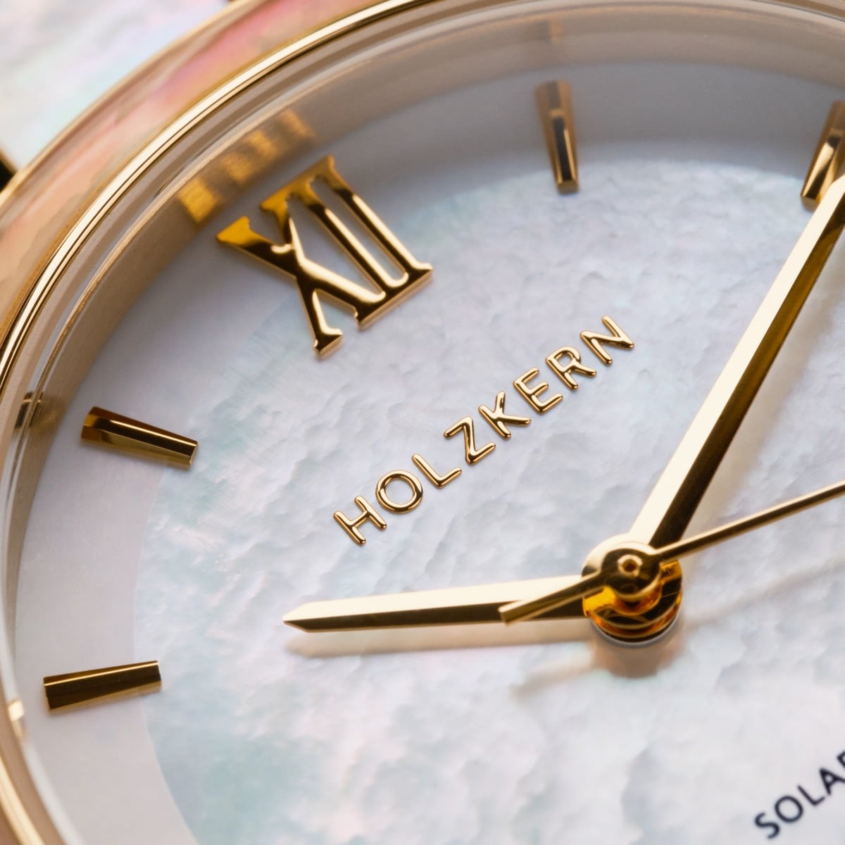"Sunglister" wristwatch featuring a white mother-of-pearl face with gold accents.