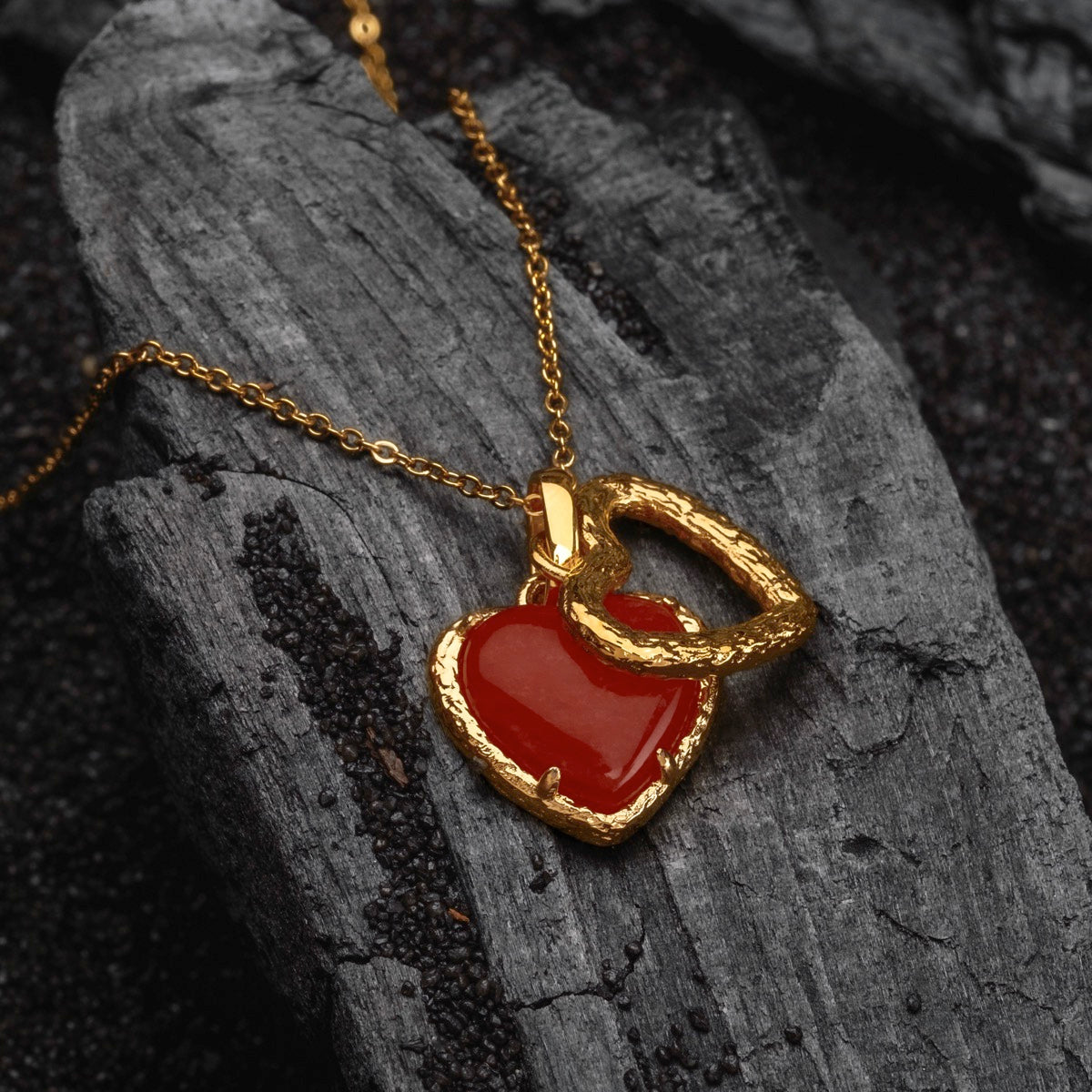 "Amorance Necklace" necklace featuring a heart-shaped chalcedony pendant with a textured gold design on a fine chain.
