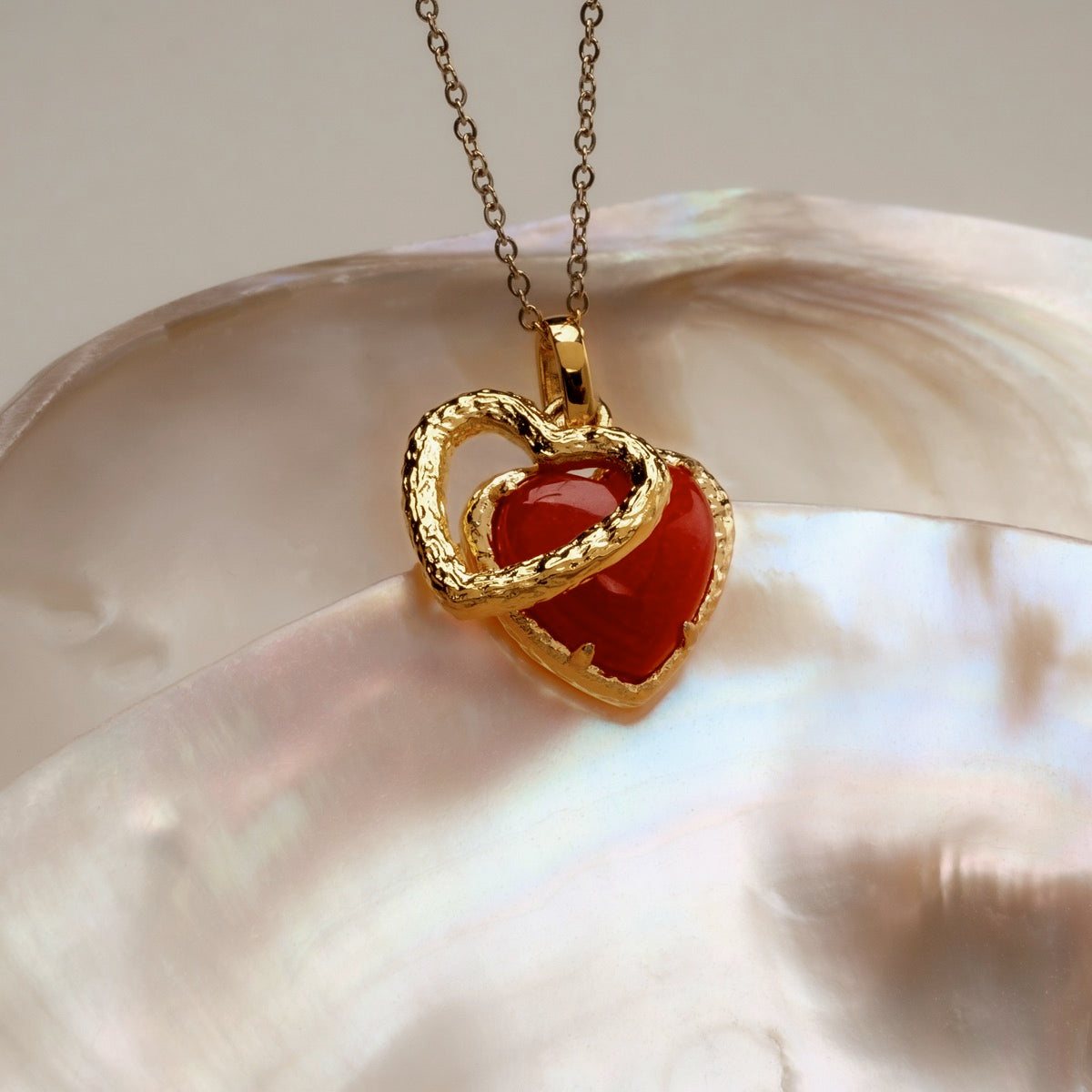 "Amorance Necklace" necklace featuring a heart-shaped design with a chalcedony stone and elegant gold accents.