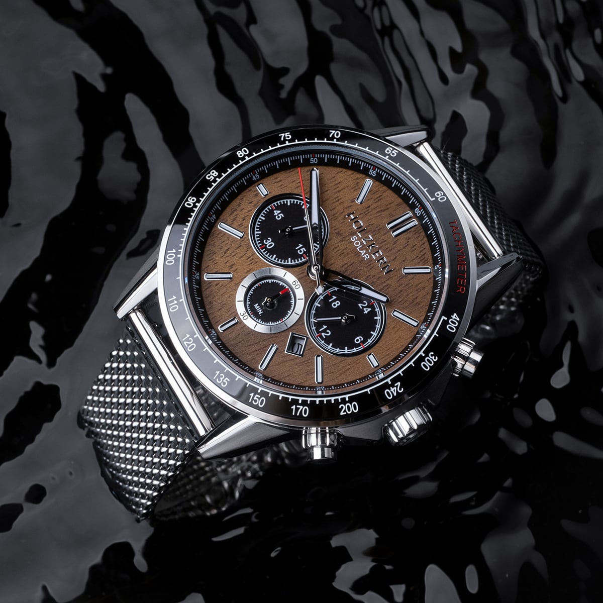 "Comfort Crusher" watch featuring a walnut dial and silver accents, stylishly designed against a reflective black surface.